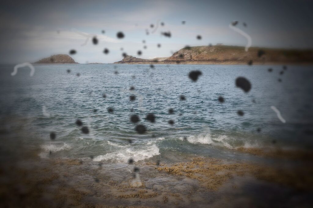 a person is experiencing floaters in their vision as they look to the ocean.