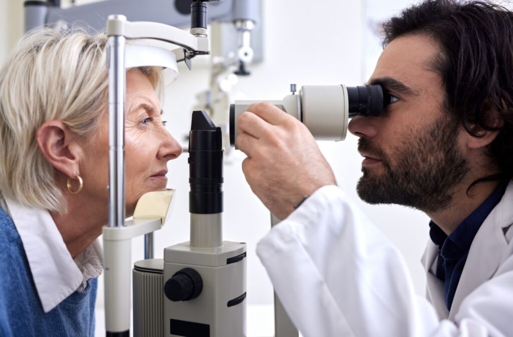 A close-up image of an optometrist examining an older adult's eyes to determine why their astigmatism has gone away.