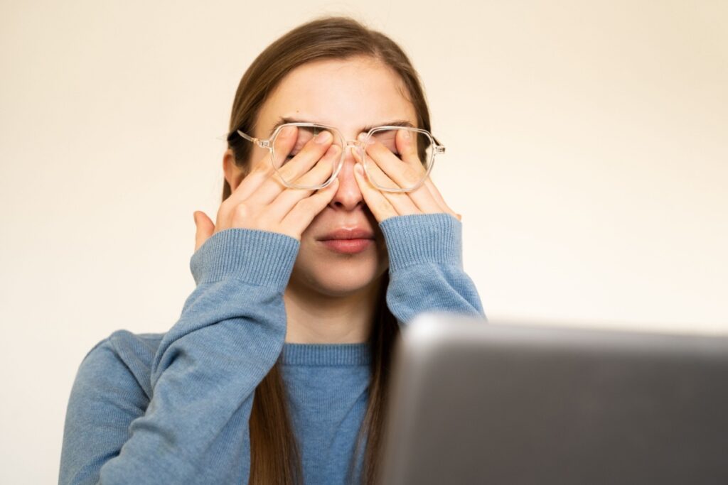 Woman rubbing her eyes under her glasses.